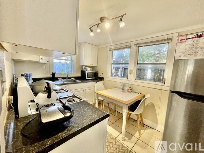 A kitchen with a black countertop and white cabinets.