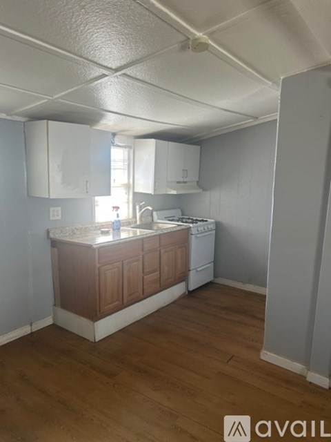 A kitchen with wooden cabinets and a white dishwasher.