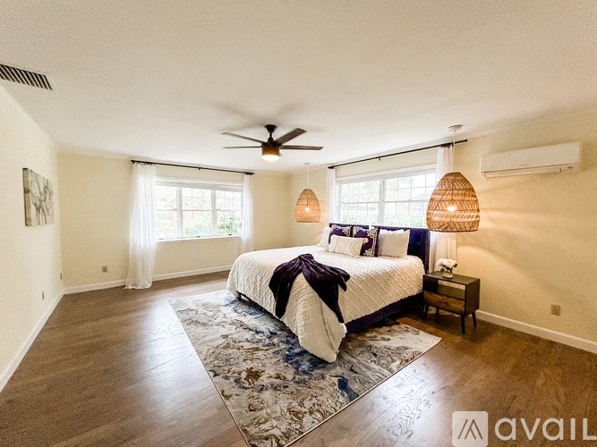 A bedroom with a large bed and a ceiling fan.