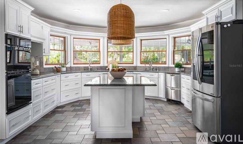 A modern kitchen with white cabinets and a central island.