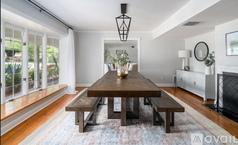 A modern dining room with a wooden table and benches.
