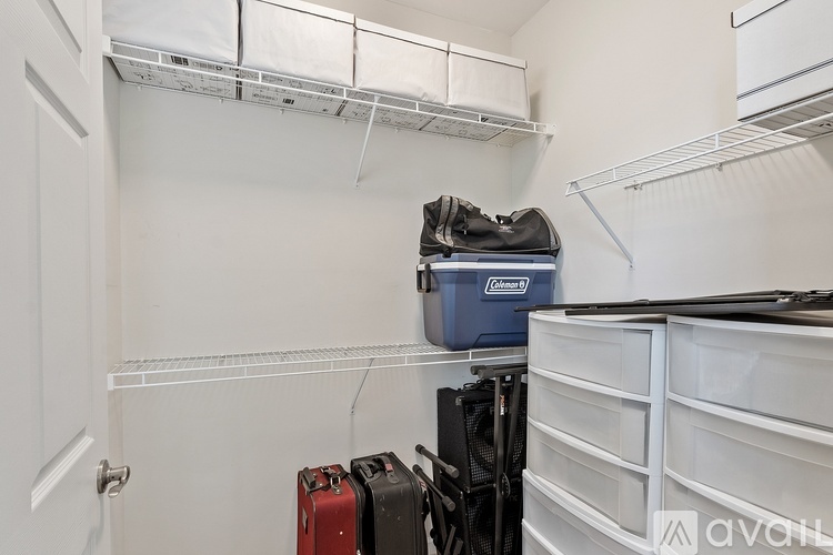 A room with a white wall and a shelf with a bag on it.