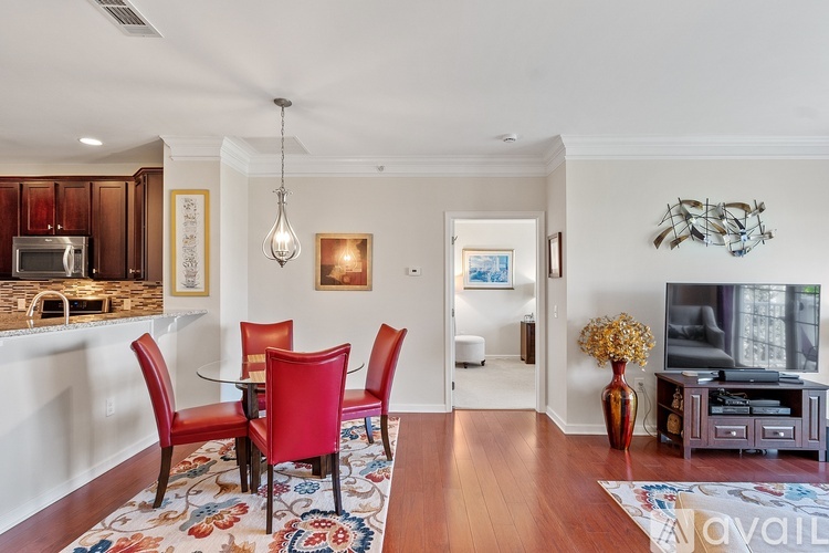A dining room with a red table and chairs.