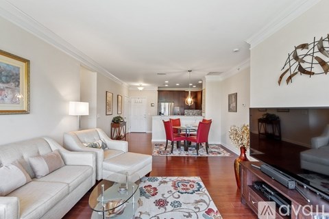 A living room with a white couch, a red chair set, and a television.