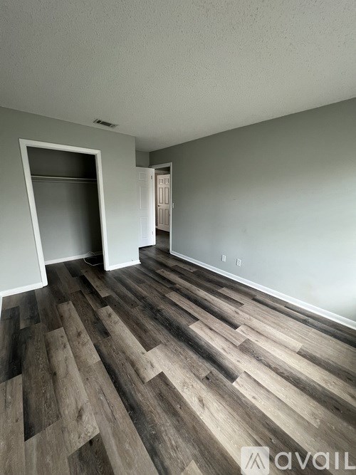 A room with wooden flooring and a white door.