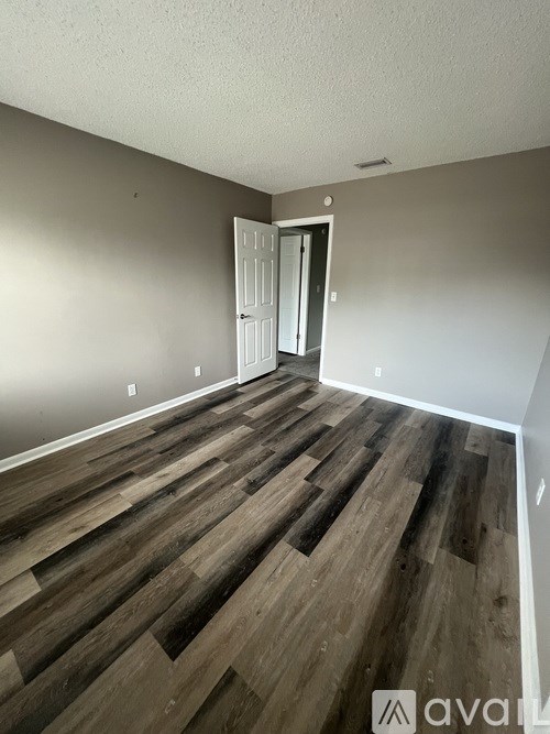 A room with wooden flooring and a white door.