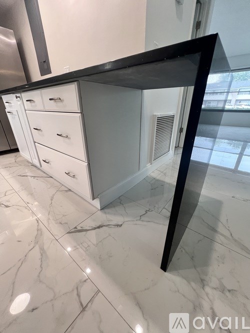 A tree is planted in a planter box on a patio.