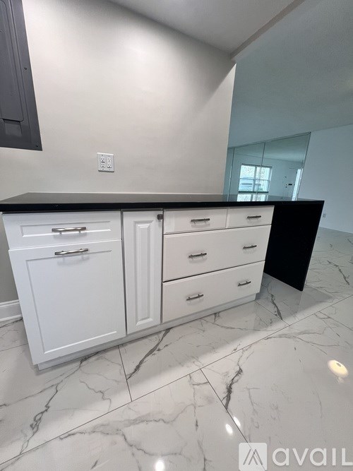 A building with a balcony and bushes in front.