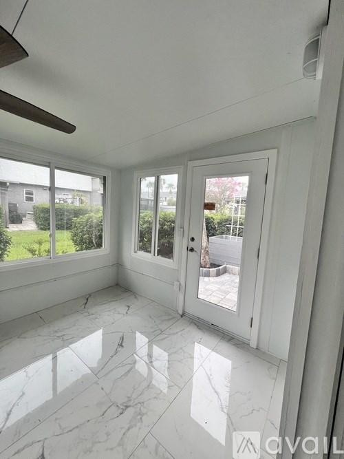 A room with a marble floor and a ceiling fan.
