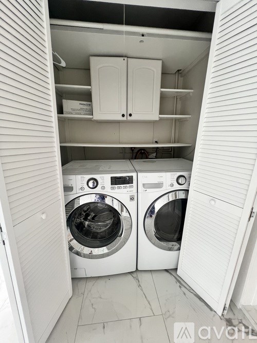 A white laundry room with two washing machines.
