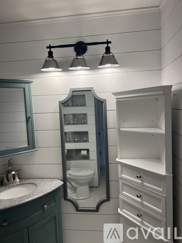 A bathroom with a sink, mirror, and medicine cabinet.