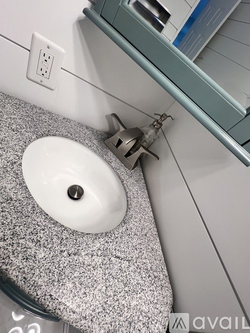 A white sink with a grey towel underneath it.