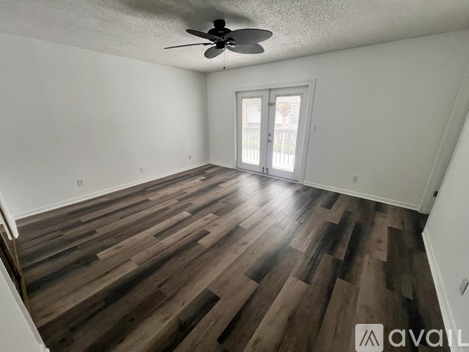 A room with wooden flooring and a ceiling fan.