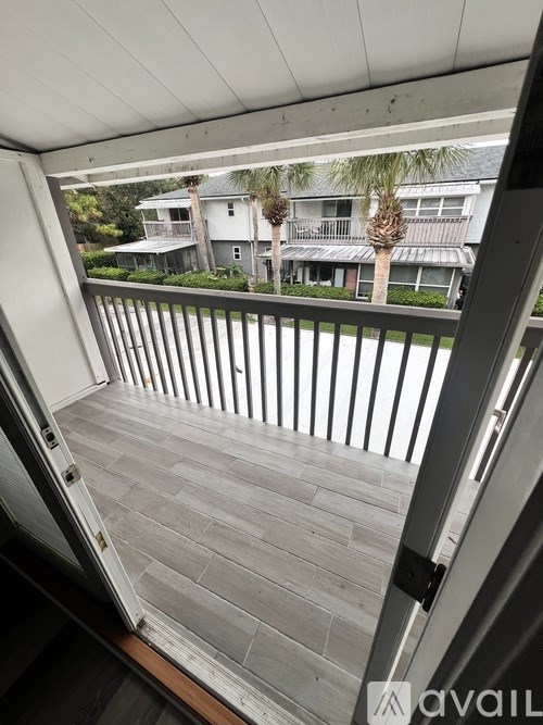 A balcony with a view of houses and trees.