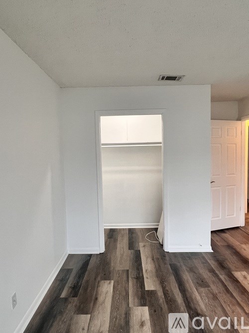A room with wooden flooring and white walls.