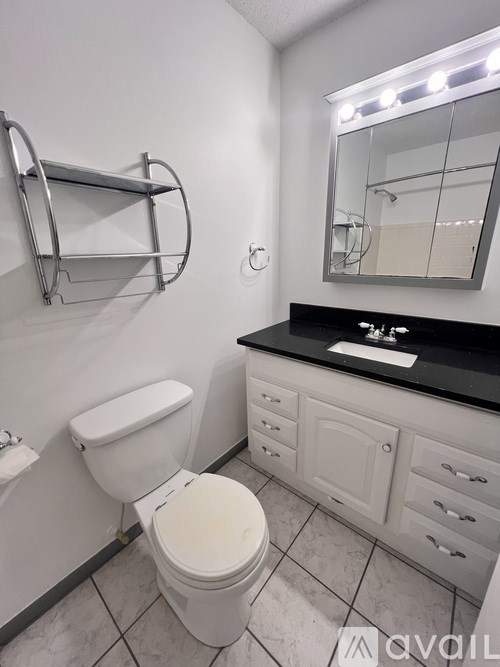 A white toilet in a bathroom with a mirror above the sink.