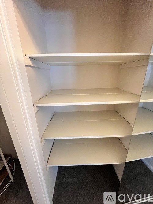 Empty shelves in a white storage unit.