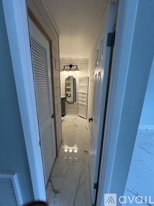 A hallway with a marble floor and white walls.