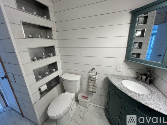 A bathroom with a toilet, sink, and a mirror.