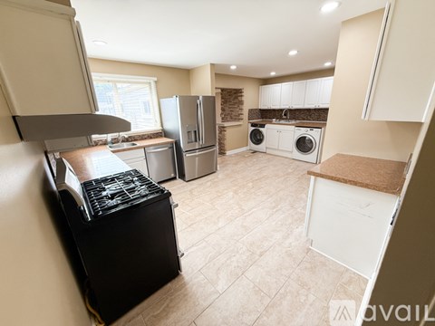 A kitchen with a black stove top oven and white appliances.