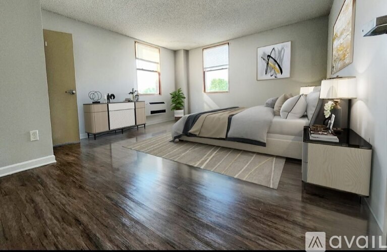 A bedroom with a large bed and a wooden floor.