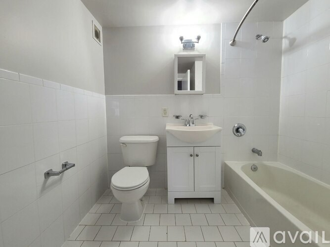 A white bathroom with a toilet, sink, and bathtub.