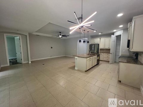 A kitchen with a tile floor and a ceiling fan with lights.