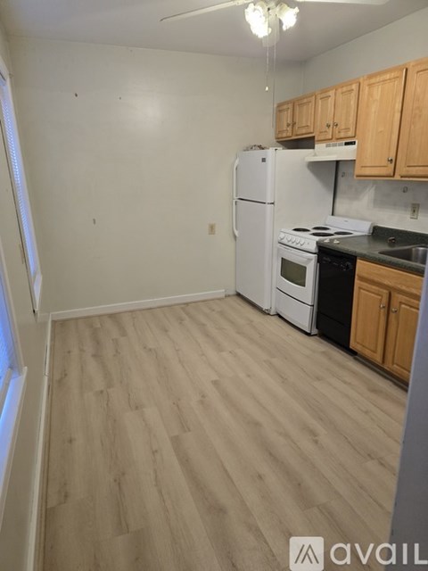A kitchen with wooden cabinets and a white refrigerator.