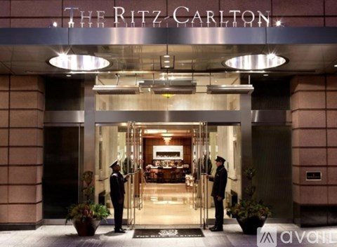 The Ritz Carlton hotel entrance with two doormen standing in front.