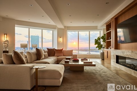 A modern living room with a large couch and a fireplace.