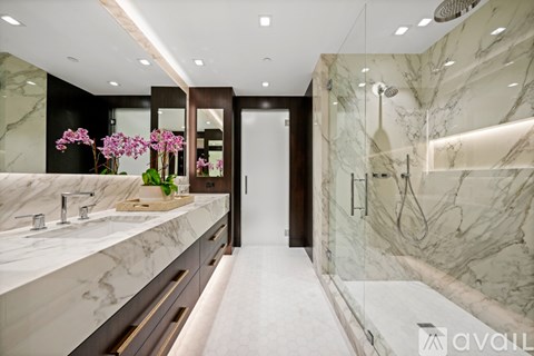 A bathroom with marble countertops and a walk-in shower.