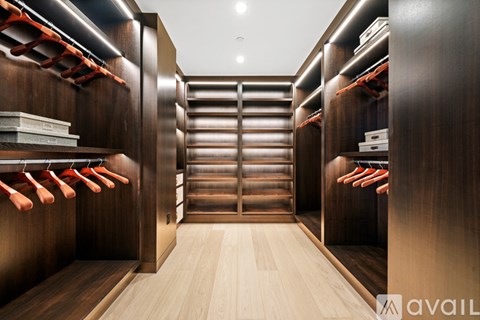 A walk-in closet with wooden shelves and drawers.