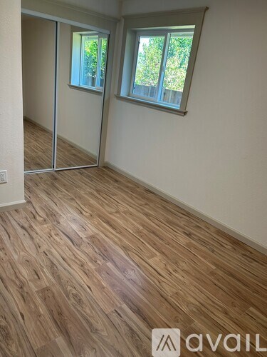 A room with a window and wooden flooring is available for rent.