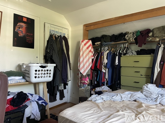 A bedroom with a bed, wardrobe and a poster on the wall.