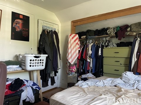 A bedroom with a bed, wardrobe and a poster on the wall.