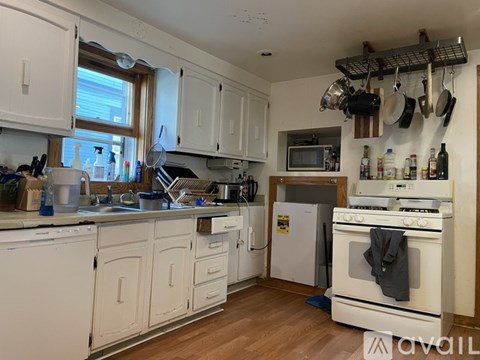 A kitchen with white cabinets and a white stove.