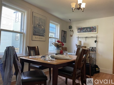 A dining room with a table set for two and a painting on the wall.