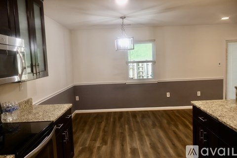 A kitchen with dark wood cabinets and granite countertops.