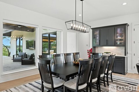 A black and white dining room with a large table and chairs.