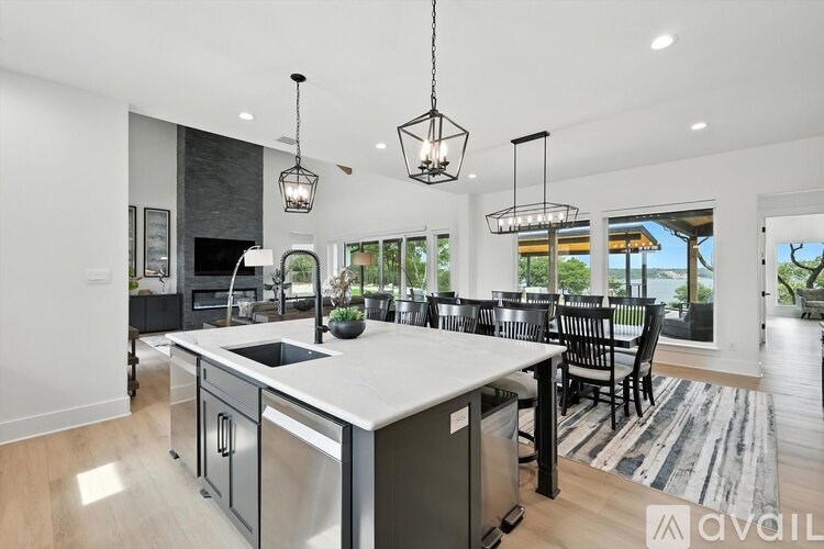 A modern kitchen with a large island and pendant lights.