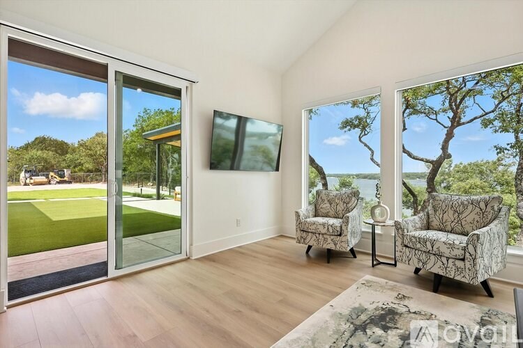 A living room with a view of a tree and a building outside the window.
