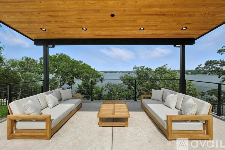 A wooden patio with two couches and a table.