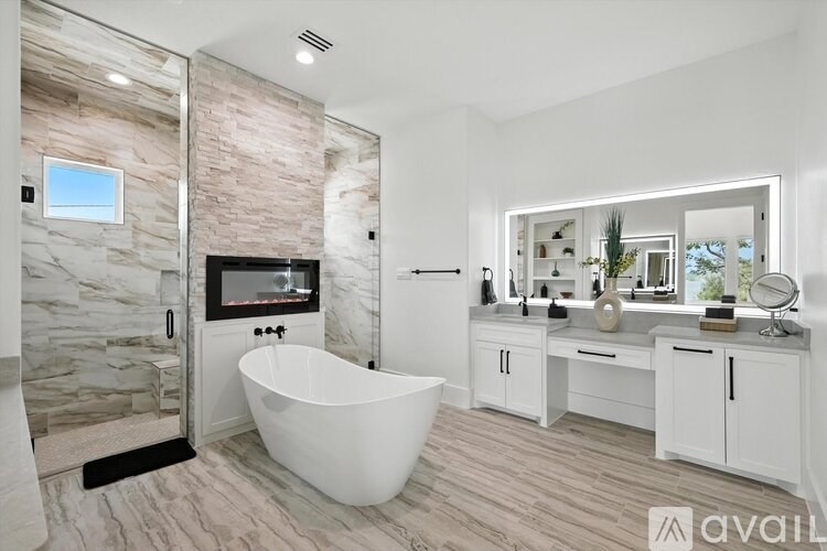 A modern bathroom with a stone wall and a large bathtub.