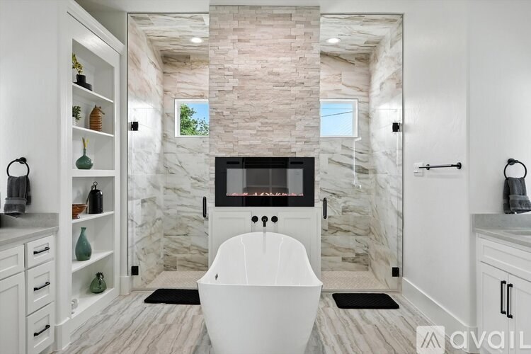 A modern bathroom with a stone wall and a white bathtub.