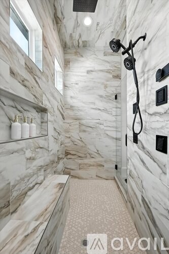 A bathroom with marble walls and floor.