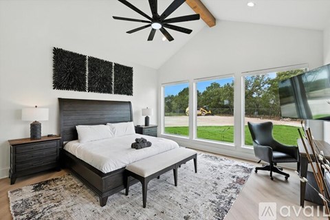 A bedroom with a large bed and a ceiling fan.