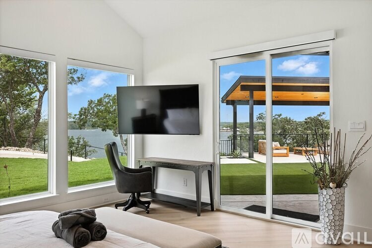 A modern living room with a flat screen TV and sliding glass doors.