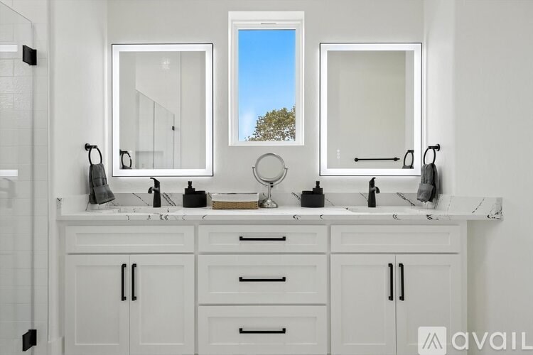 A bathroom with two sinks and a window.