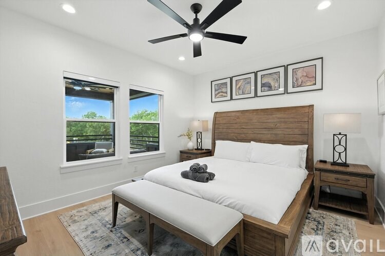 A bedroom with a large bed and a ceiling fan.