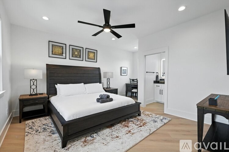 A bedroom with a large bed and a ceiling fan.